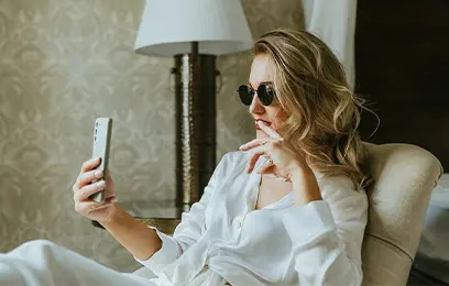 Γυναίκα ξαπλωμένη σε κρεβάτι που χρησιμοποιεί smartphone σε εσωτερικό χώρο