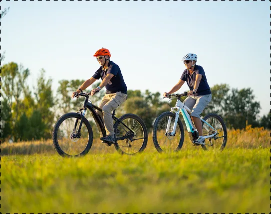 Ένας άντρας και μία γυναίκα οδηγούν τα e-bike τους στην εξοχή