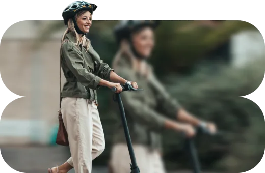 Κοπέλα με κράνος οδηγεί ηλεκτρικό πατίνι.  