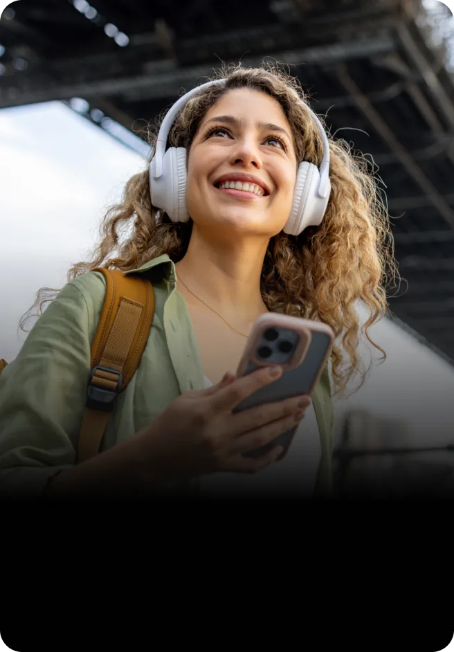 The On-the-Go: Γυναίκα ακούει μουσική στα ακουστικά της μέσω του κινητού της.